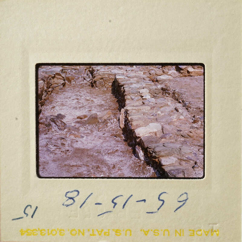 Stone ruins with exposed layers and dirt, photographed on an old slide.