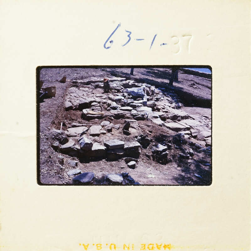 A photograph showing an archaeological excavation site with exposed stone structures and layers.