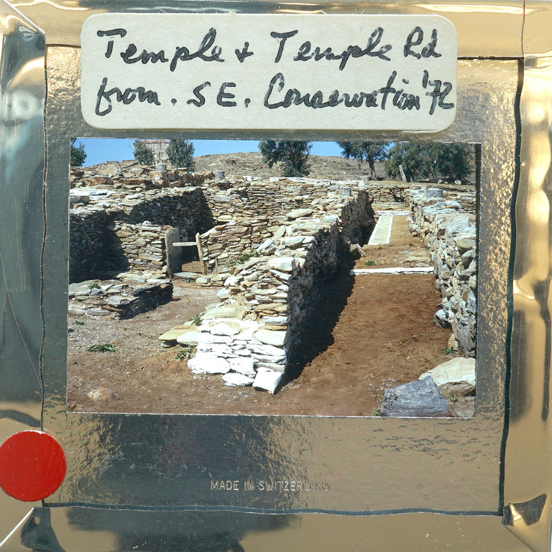 The image shows an old stone structure, possibly ruins, with a dirt path leading through it.