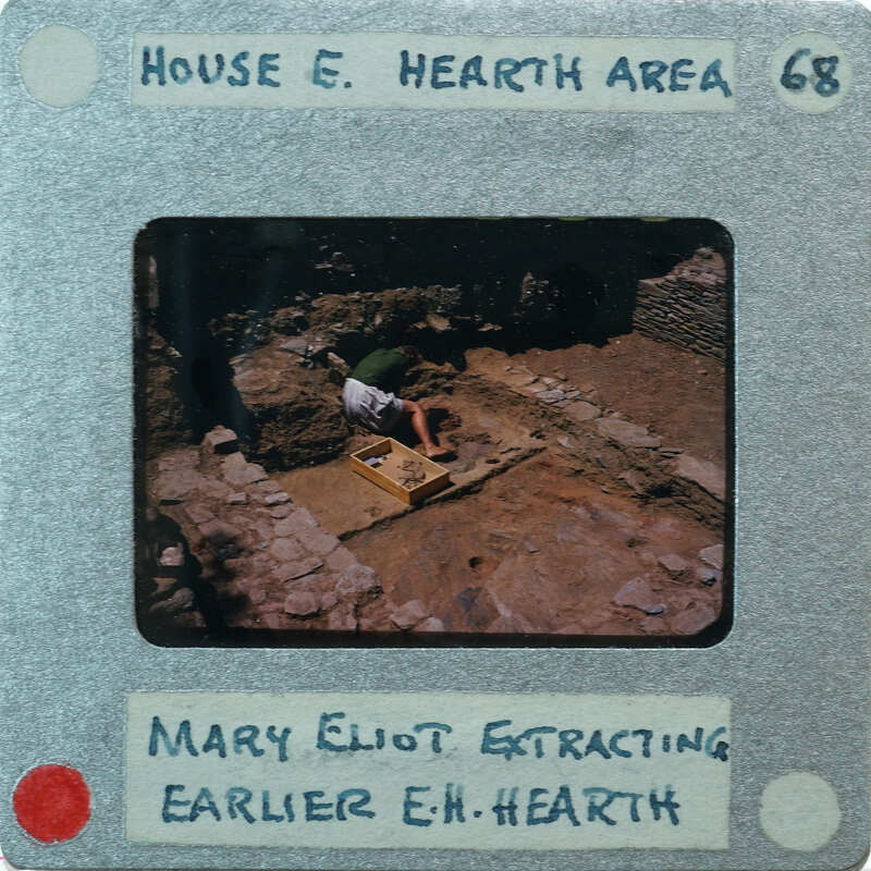 A photo of a person working on an archaeological site with a label describing the scene.