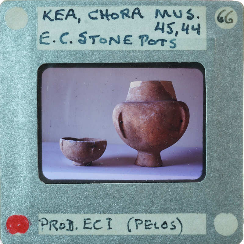 Two stone pots, short bowl on left, taller piece with fake handles on right, in profile.