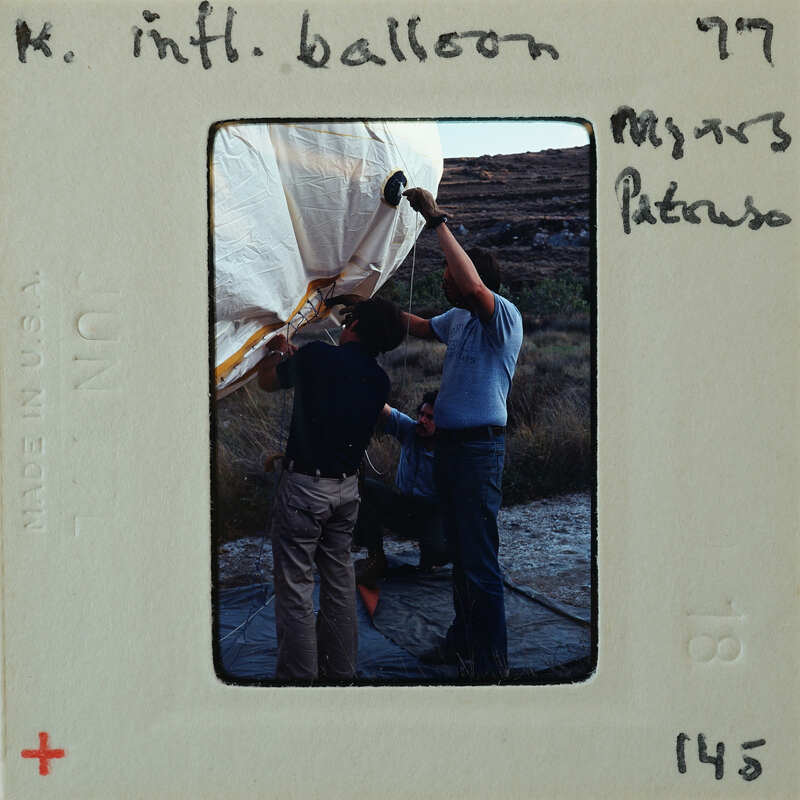 Two men working on a large balloon.