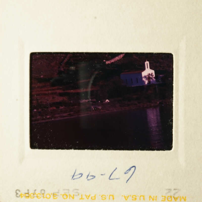 A scenic view of a church and waterfront, captured on an old photograph.