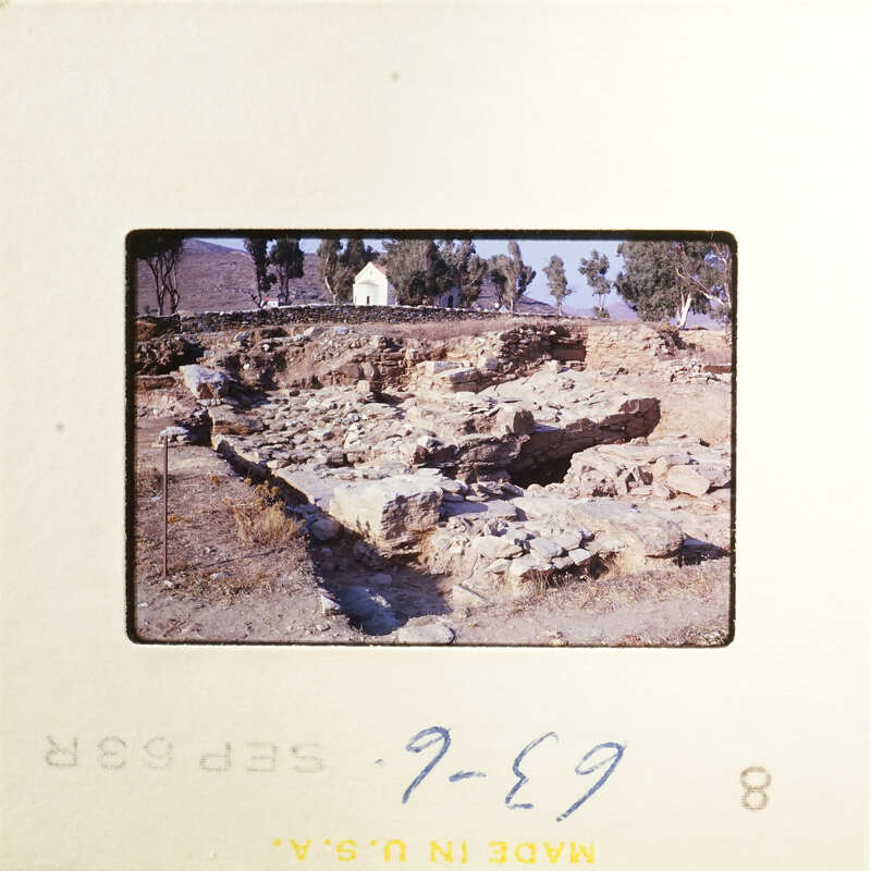 A photograph of an ancient archaeological site with ruins and vegetation.