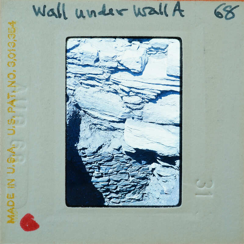 A black and white photograph of a rocky cliff face.