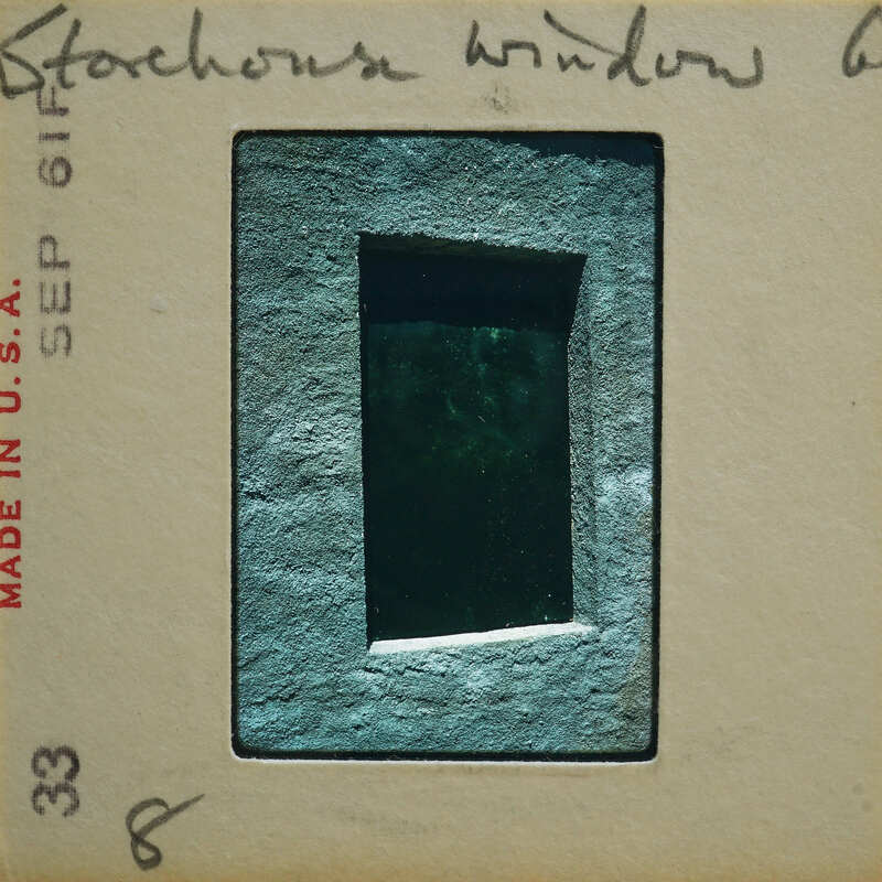 Photo of a window with an image of the moon visible through it, on a vintage film strip.