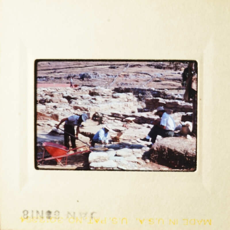 People working on an excavation site with tools and dirt.