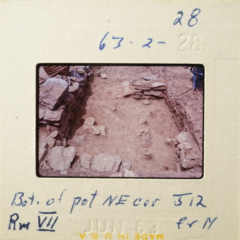 A photograph showing an excavation site with stone ruins and dirt.