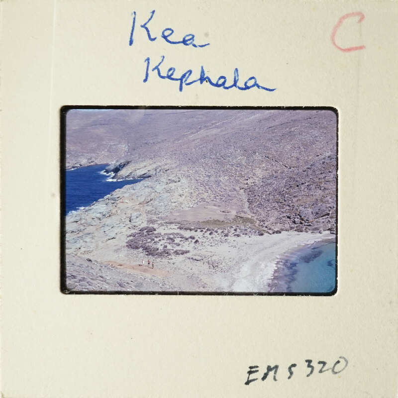 Scenic landscape photo with blue water and rocky terrain, labeled "KEA KEPHALA" on a white mount.