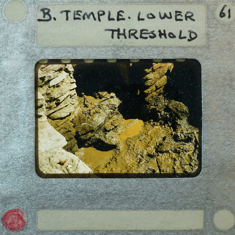 Detail of stone walls forming a doorway with water forming puddles at the bottom