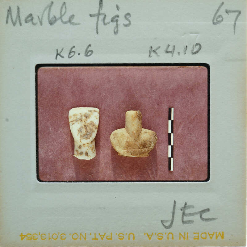 Two small, ancient objects on a white surface with labels.