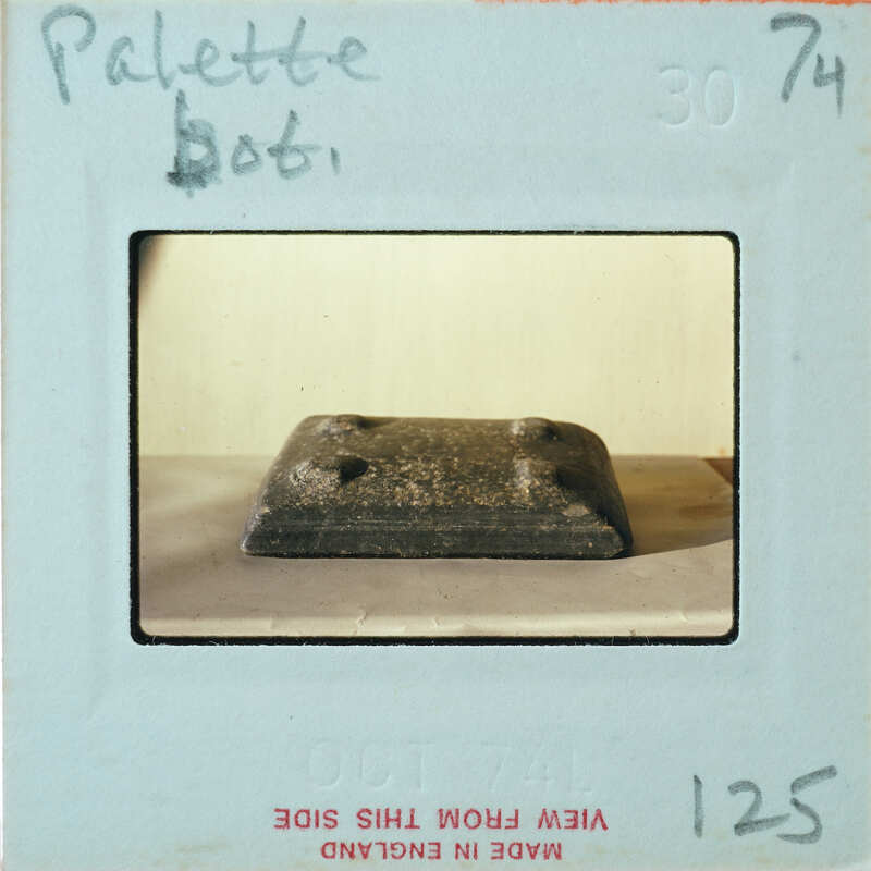 Small square object with bumps in corners.