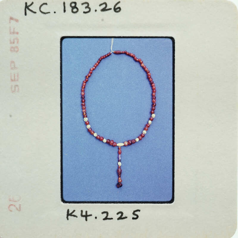 Red bead necklace with a pendant on display.