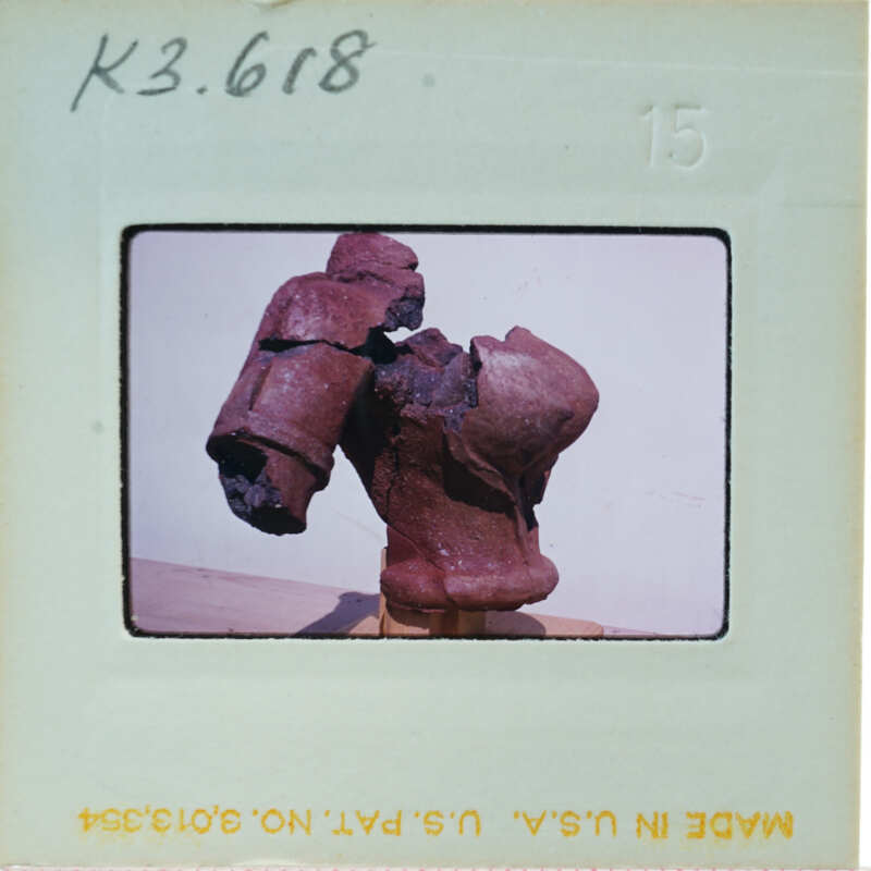 Terracotta figurine torso from side.