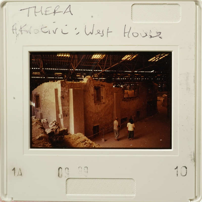 A photograph showing an old building with people standing outside, possibly taken from a vintage film strip.