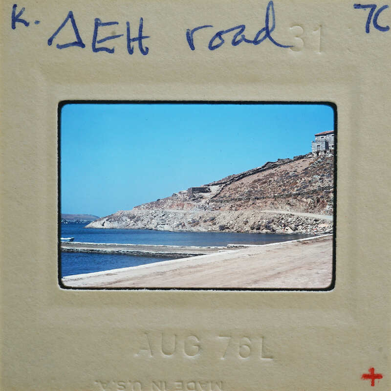 A vintage photograph of a coastal landscape with a rocky shore and body of water, enclosed within an old photo frame.