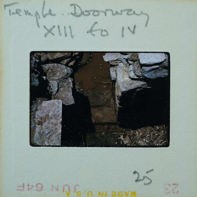 Marble step and doorway in muddy floor of building interior.