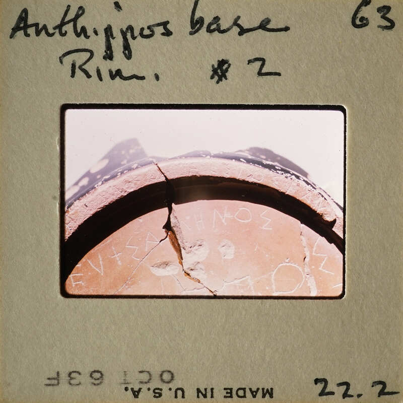 Cracked ancient Greek coin with inscriptions.