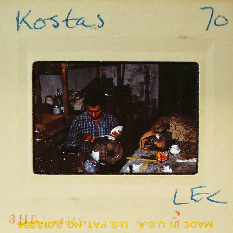 A man working on pottery at a wheel, captured in an old photograph with handwritten details and postage marks.