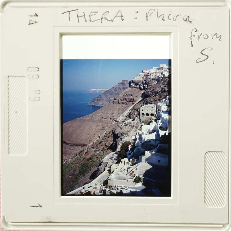 A photo of an island with houses built into steep cliffs.
