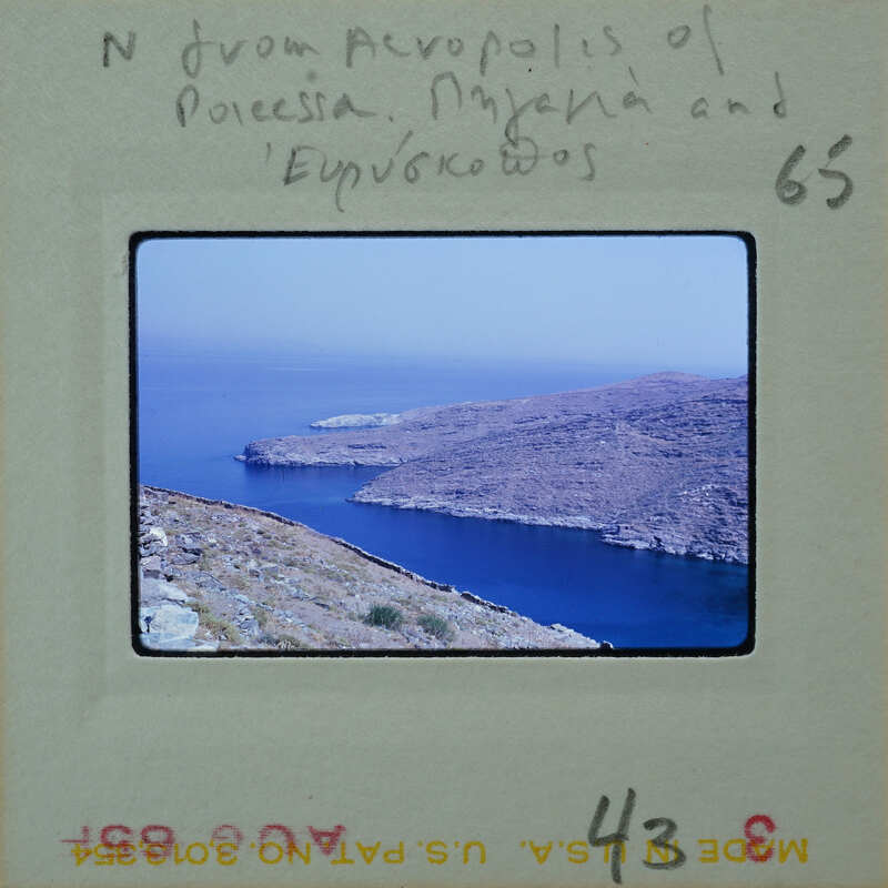 A vintage film strip with a photograph of a coastal landscape, possibly from the Mediterranean region.