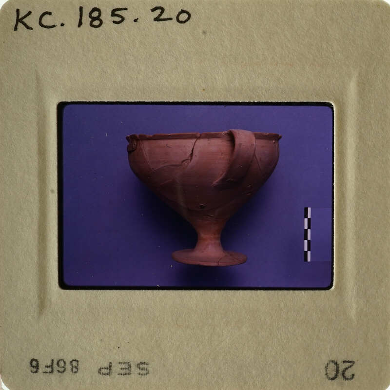 Ancient clay cup with handle on display.