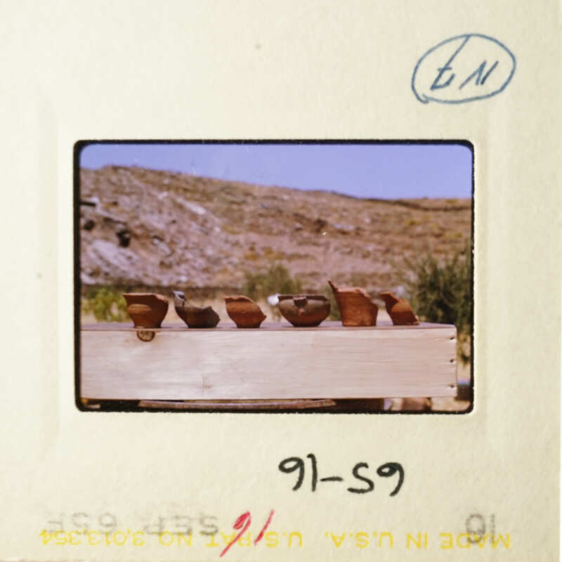 A vintage photo of pottery displayed on a wooden table.