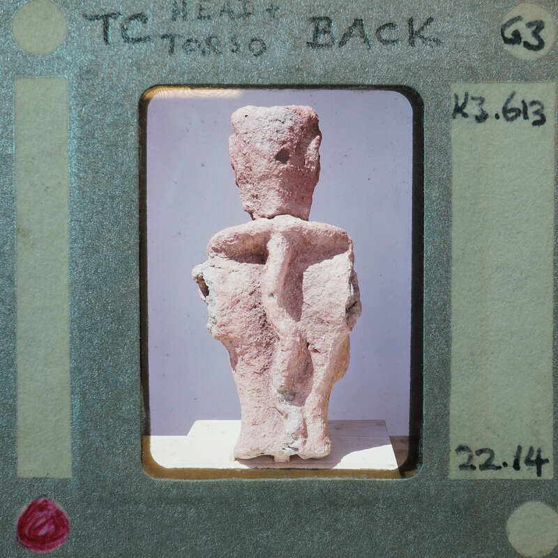 Terracotta figurine fragment (K3.613) from back showing head and torso.