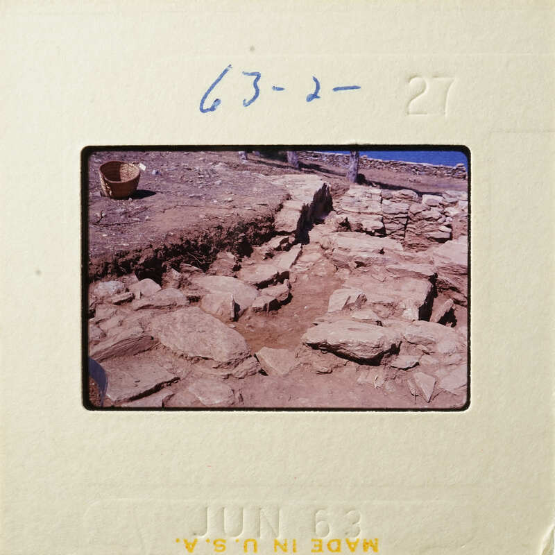 Stone ruins with scattered rocks and debris, possibly an archaeological site.