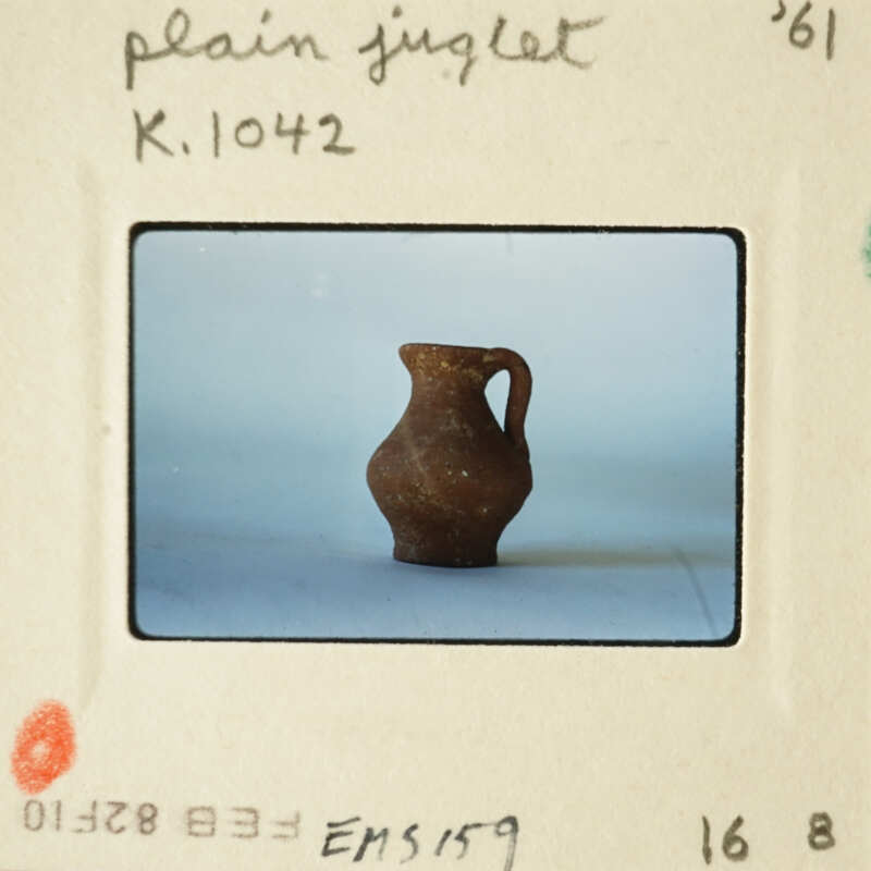 Brown clay vase on white surface.
