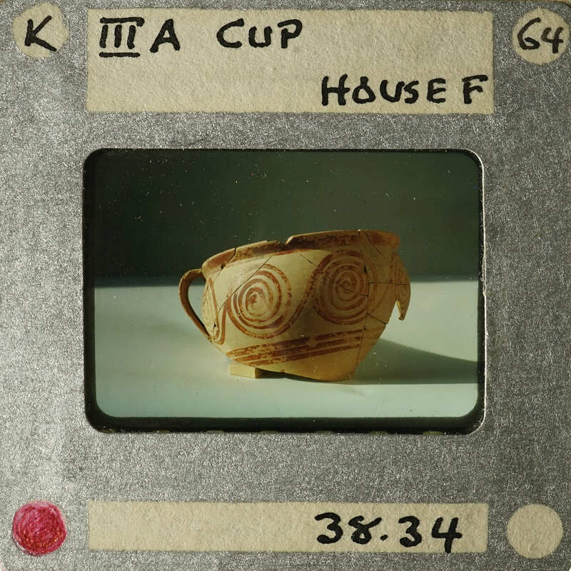 Ancient ceramic cup with intricate designs on display.