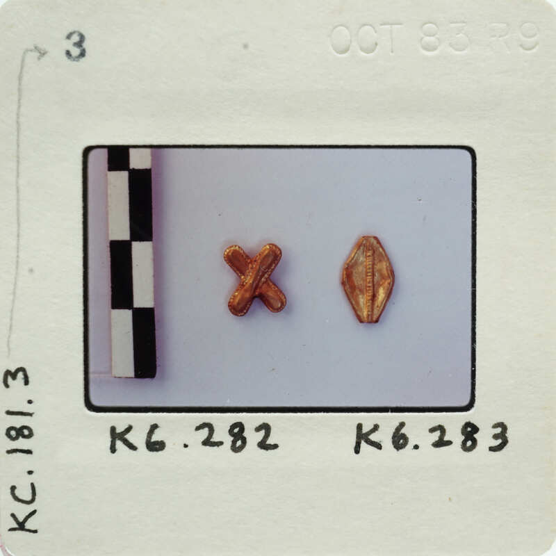 Two gold color metallic pieces; one bead shaped and one X-shaped.