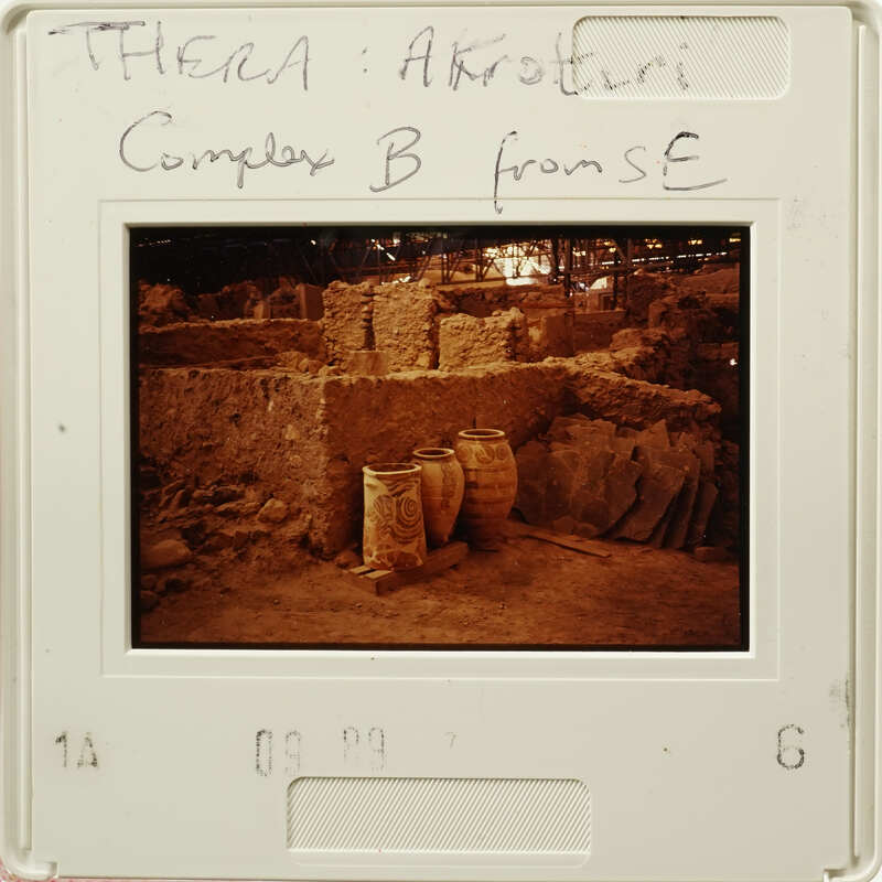 Old photograph of an archaeological site with stone ruins and clay jars.