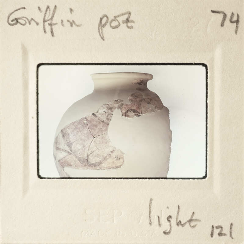 A photograph of a broken pot with a handwritten label on it.