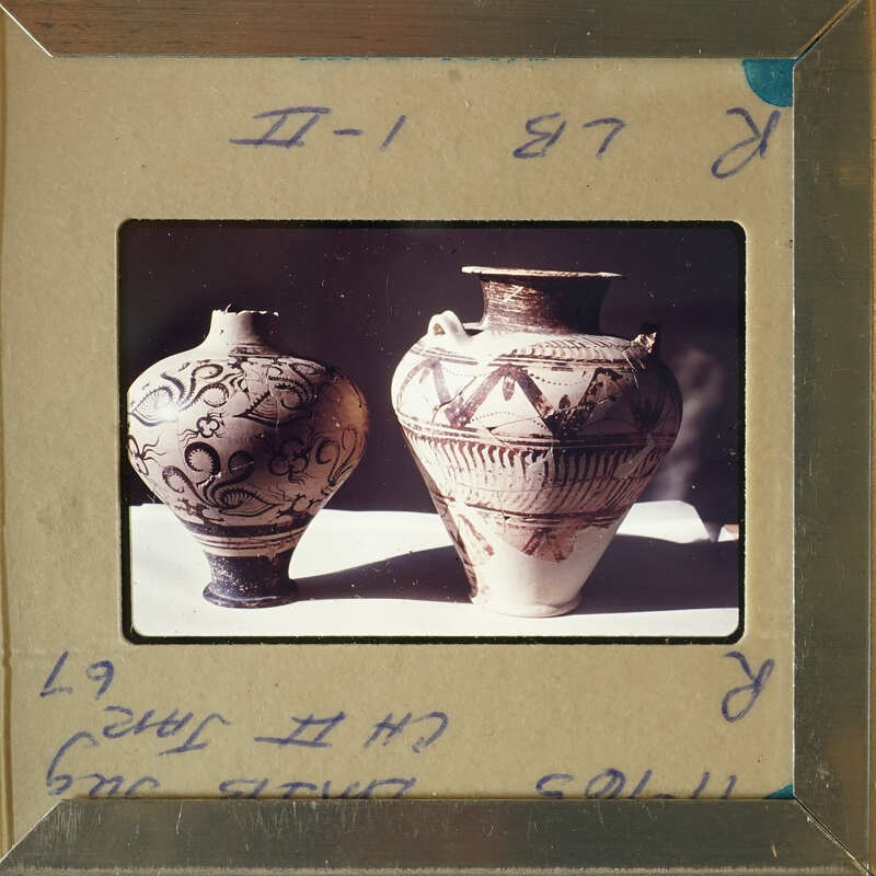 Two antique vases with intricate designs on display.