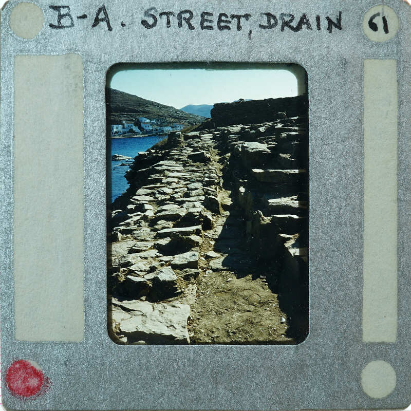 This is a vintage film strip with a label that reads "A-Street Drain" and features an image of a rocky coastline.