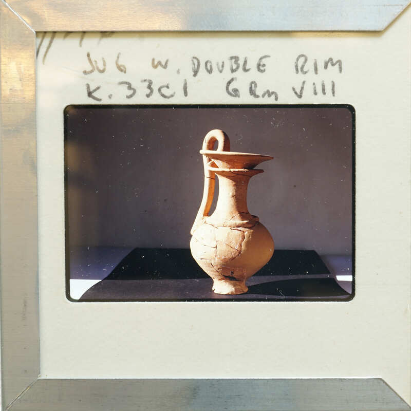 A jug with a double rim in profile on a table.