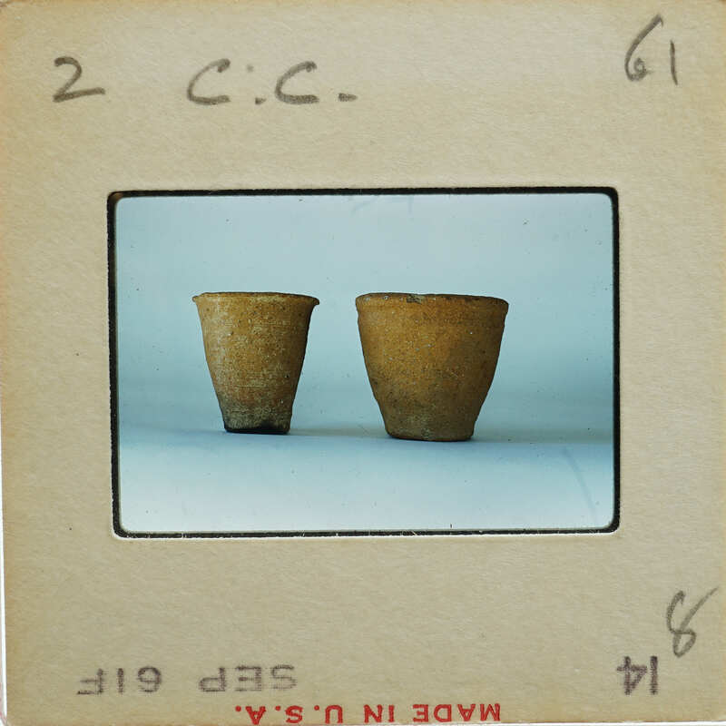 Two brown ceramic pots on a white surface.
