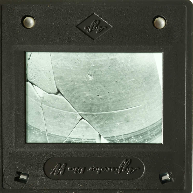 Old photograph displayed on damaged glass plate.