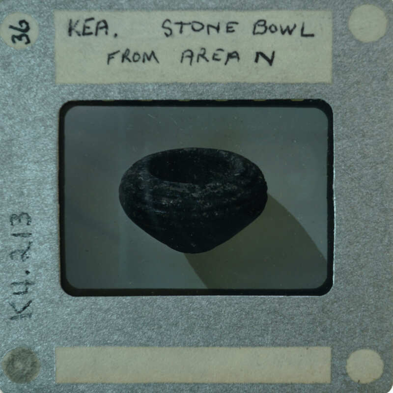 A black and white photograph of a stone bowl with a label.