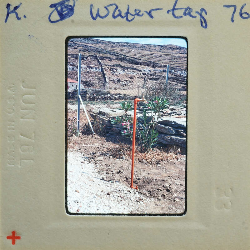 A photograph of a dirt field with orange poles and rocks, taken on June 7, 1976.