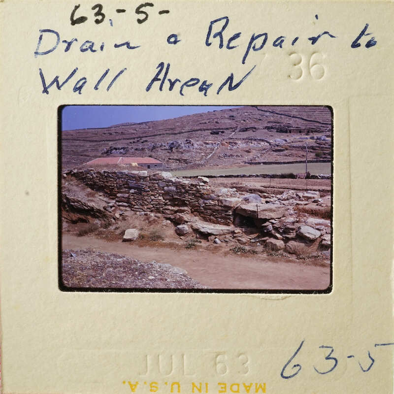 A wall with stones and grass on top, possibly part of an ancient structure.