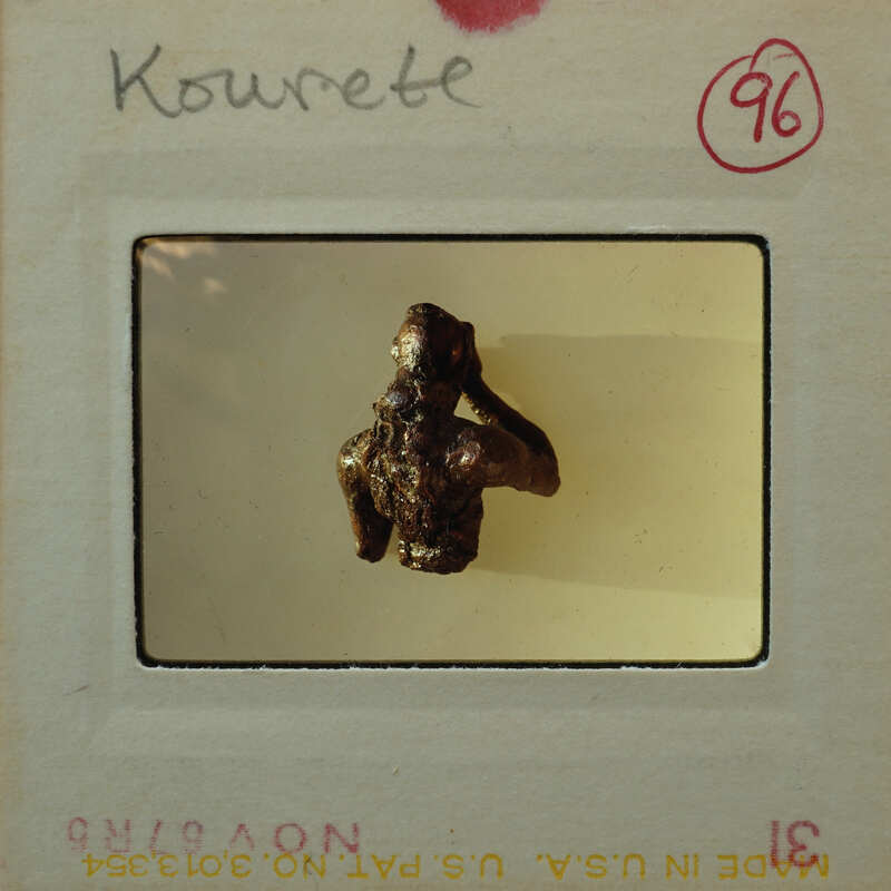 Small sculpture on display of person from the torso up from the rear.