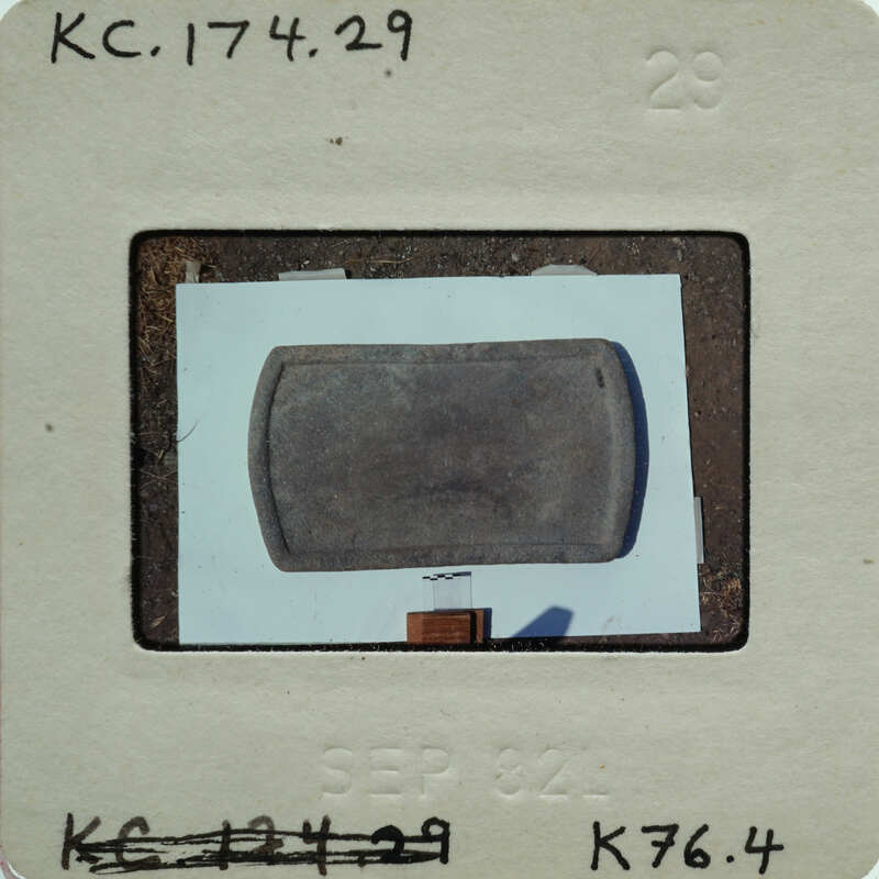 A small, square object with a label on it, possibly an artifact or specimen.