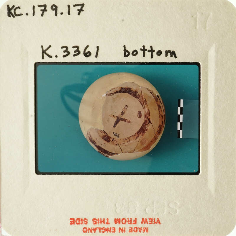 Old photograph of an object with markings, possibly a ball or sphere, on a blue background.