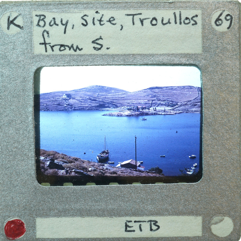 A photograph of a scenic bay with mountains, boats, and water.