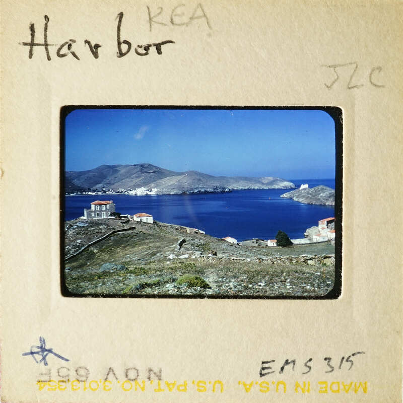 A scenic view of an island with houses, water, and mountains.