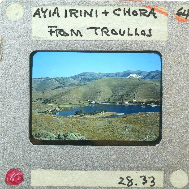 A photograph of a scenic landscape with mountains and a lake, taken from Chora on Ikaria Island.