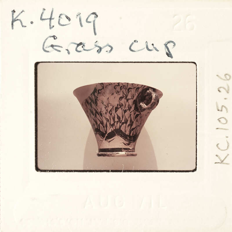 A photograph of a decorative ceramic cup with an intricate design on display.