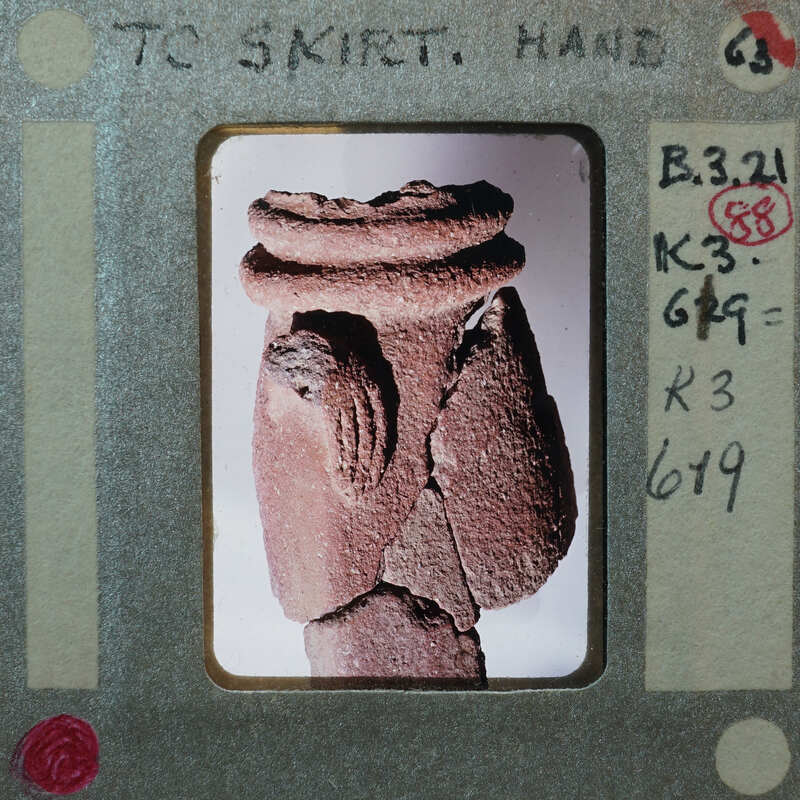 Partially reassembled fragments of terracotta figurine showing belt and hand, K3.619.